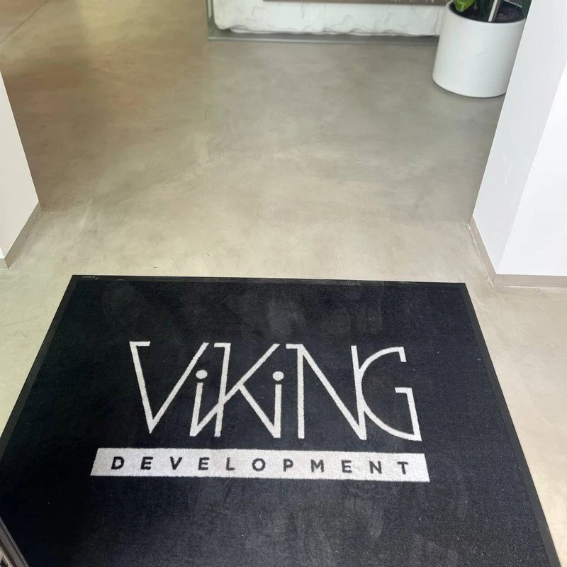 Чорний килимок з білим логотипом Viking Development