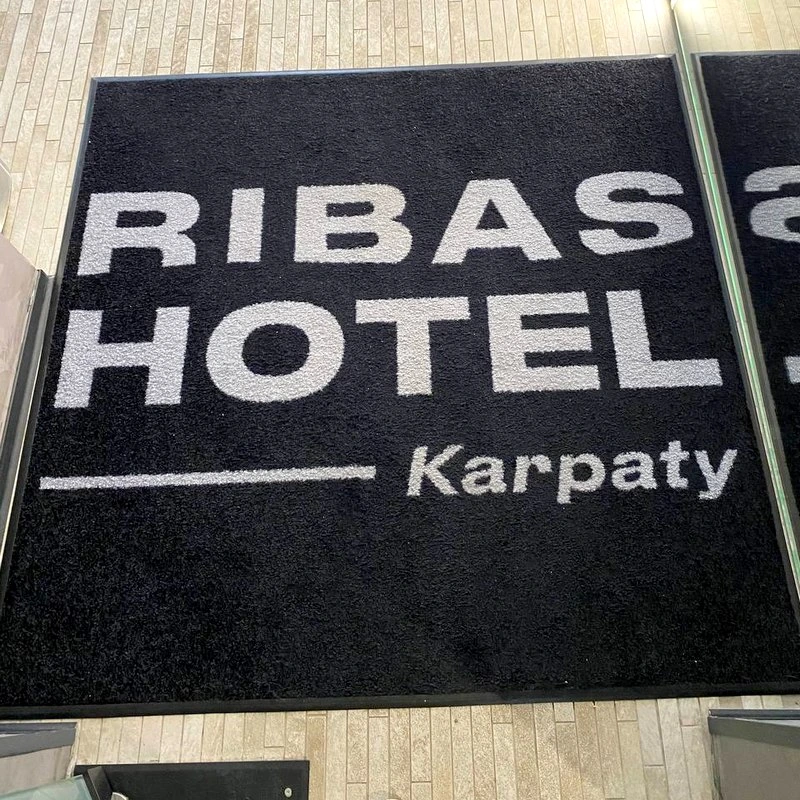 Чорно-білий килимок з логотипом Ribas Hotel