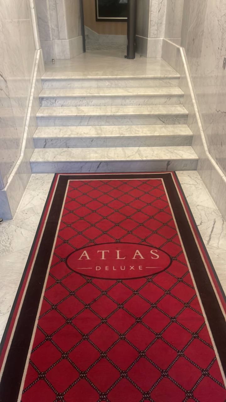 Довгий червоний килимок Atlas Deluxe у мармуровому холі