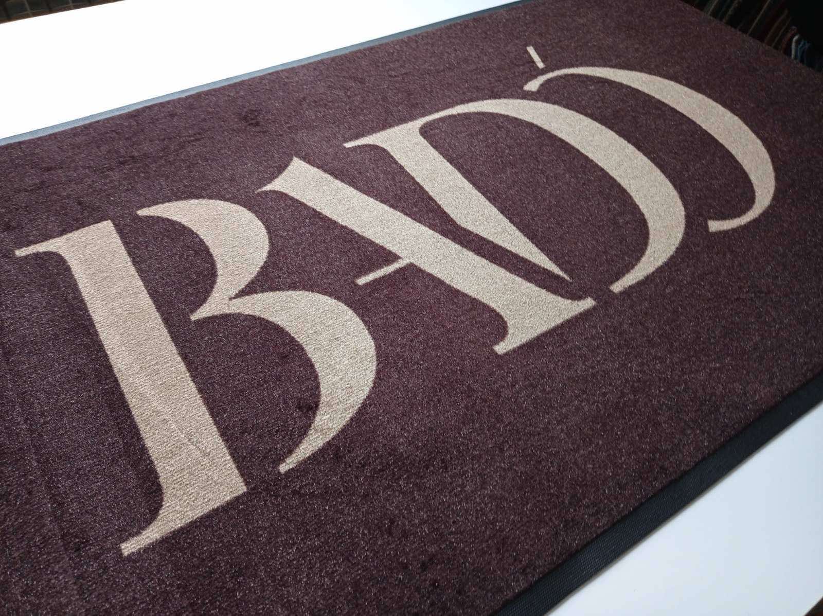 Бордовий килимок з великою світлою монограмою BND